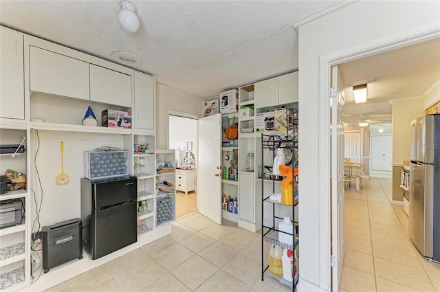 1908 N Brink Ave, Sarasota, FL 34234 - kitchen featuring open shelves, freestanding refrigerator, light tile patterned floors, and a textured ceiling