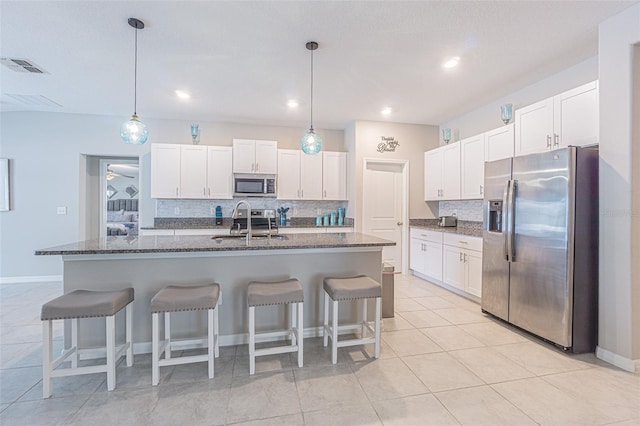 13527 Willow Bluestar Loop, Riverview, FL 33579 - kitchen featuring appliances with stainless steel finishes, tasteful backsplash, white cabinets, a kitchen breakfast bar, and pendant lighting