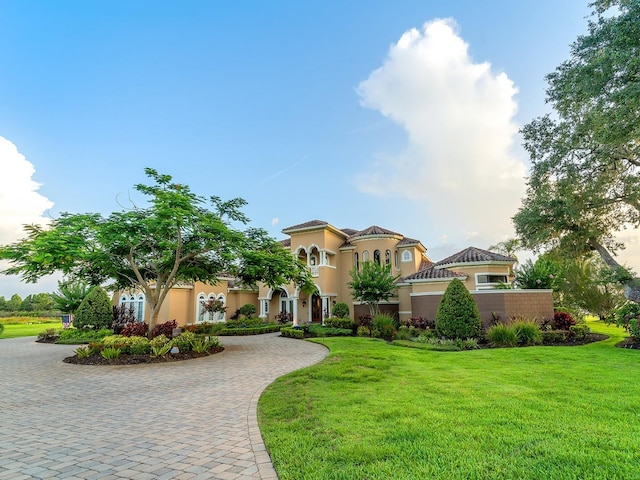 12125 Stonelake Ranch Blvd, Thonotosassa, FL 33592 - mediterranean / spanish home with stucco siding, a front yard, and curved driveway