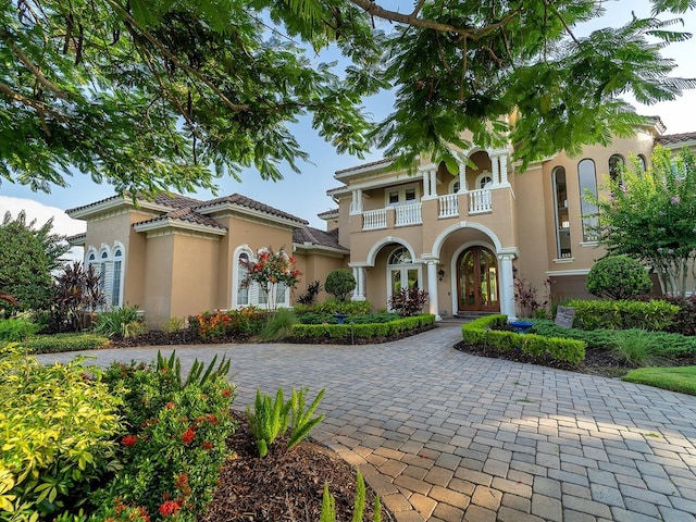 12125 Stonelake Ranch Blvd, Thonotosassa, FL 33592 - mediterranean / spanish-style home featuring a balcony, french doors, stucco siding, and decorative driveway