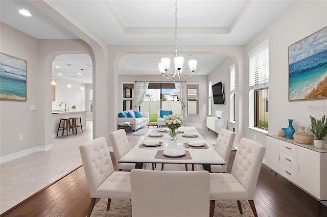 3994 Medicci Ln, Wesley Chapel, FL 33543 - dining area featuring a chandelier, arched walkways, and dark wood finished floors