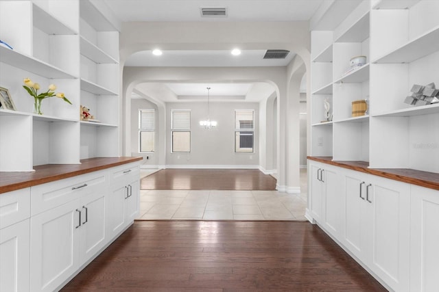 3994 Medicci Ln, Wesley Chapel, FL 33543 - bar with arched walkways, a chandelier, wood finished floors, and built in shelves