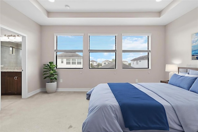 3994 Medicci Ln, Wesley Chapel, FL 33543 - bedroom featuring a tray ceiling, multiple windows, light carpet, and connected bathroom