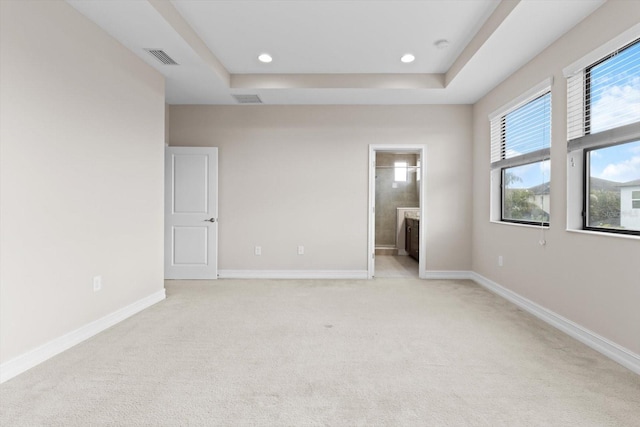 3994 Medicci Ln, Wesley Chapel, FL 33543 - unfurnished bedroom featuring light carpet, a tray ceiling, ensuite bathroom, and recessed lighting