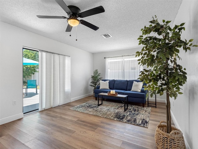 1675 E Grovehill Rd, Palm Harbor, FL 34683 - living room with plenty of natural light, wood finished floors, a textured ceiling, and a ceiling fan