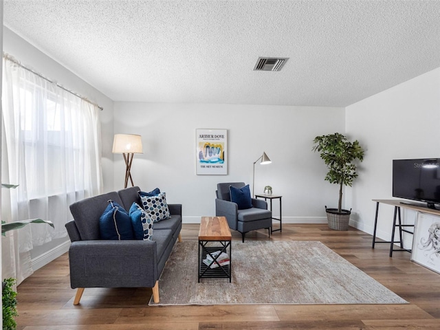 1675 E Grovehill Rd, Palm Harbor, FL 34683 - living area with a textured ceiling and wood finished floors