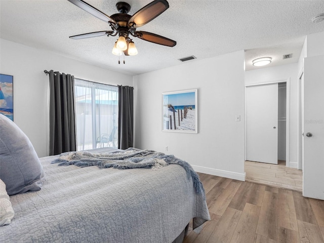1675 E Grovehill Rd, Palm Harbor, FL 34683 - bedroom featuring wood finished floors, a textured ceiling, and ceiling fan