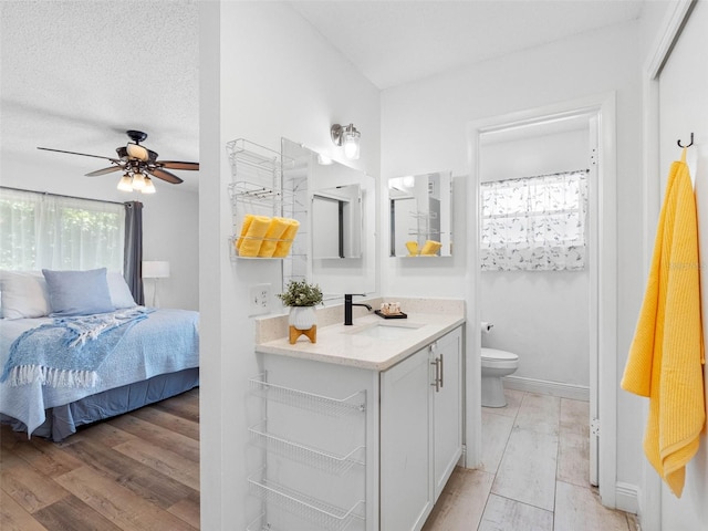 1675 E Grovehill Rd, Palm Harbor, FL 34683 - ensuite bathroom with vanity, a ceiling fan, and wood finished floors