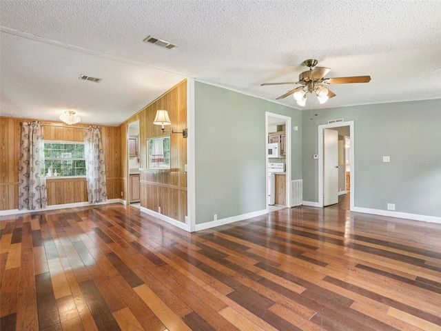 26223 Chianina Dr, Wesley Chapel, FL 33544 - unfurnished living room with hardwood / wood-style floors, a textured ceiling, ceiling fan, wooden walls, and ornamental molding
