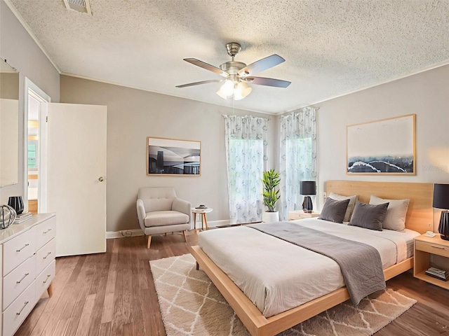 26223 Chianina Dr, Wesley Chapel, FL 33544 - bedroom with a textured ceiling, light wood-style flooring, ceiling fan, and ornamental molding