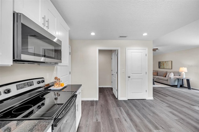 1561 S Martin Luther King Jr Ave, Clearwater, FL 33756 - kitchen featuring stainless steel appliances, wood finished floors, white cabinets, recessed lighting, and a textured ceiling
