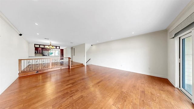459 Haven Point Dr, Treasure Island, FL 33706 - unfurnished living room featuring a chandelier, light wood finished floors, crown molding, recessed lighting, and stairs