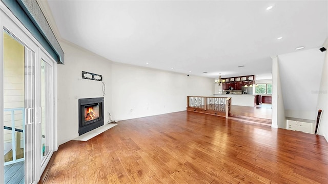459 Haven Point Dr, Treasure Island, FL 33706 - unfurnished living room featuring a fireplace with flush hearth, light wood-type flooring, recessed lighting, and a chandelier