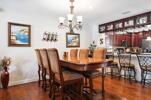 459 Haven Point Dr, Treasure Island, FL 33706 - dining room featuring a chandelier, crown molding, and dark wood-style floors