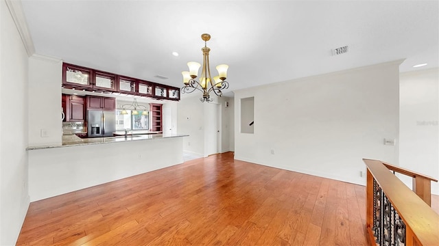 459 Haven Point Dr, Treasure Island, FL 33706 - unfurnished living room with a chandelier, light wood-style flooring, recessed lighting, and crown molding