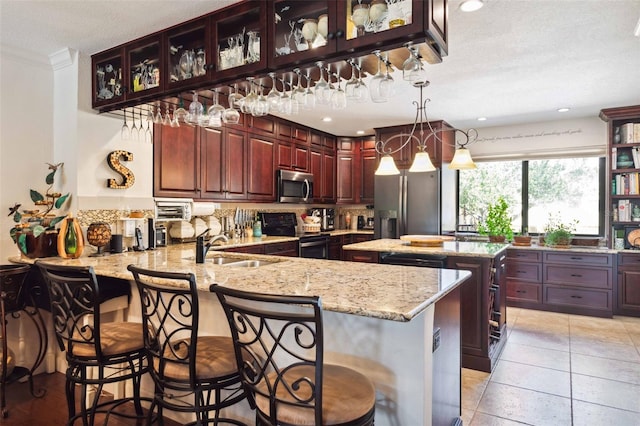459 Haven Point Dr, Treasure Island, FL 33706 - kitchen featuring appliances with stainless steel finishes, a peninsula, light stone counters, crown molding, and a kitchen island