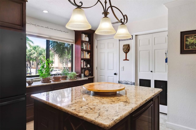 459 Haven Point Dr, Treasure Island, FL 33706 - kitchen featuring freestanding refrigerator, beverage cooler, light stone countertops, a center island, and dark brown cabinets