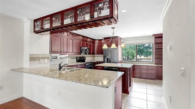 459 Haven Point Dr, Treasure Island, FL 33706 - kitchen featuring appliances with stainless steel finishes, dark brown cabinets, backsplash, light stone countertops, and a kitchen island