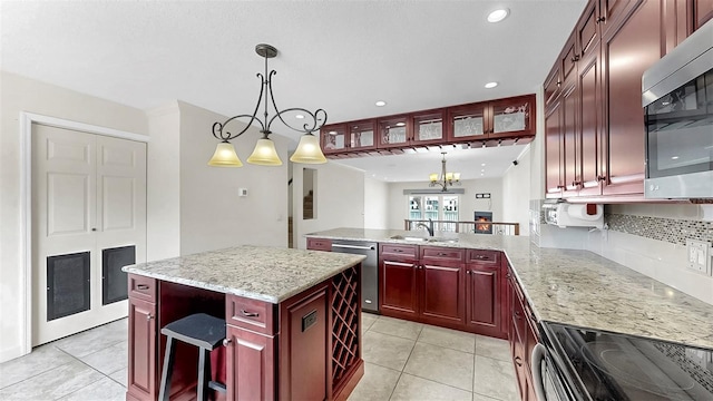 459 Haven Point Dr, Treasure Island, FL 33706 - kitchen featuring dark brown cabinets, stainless steel appliances, light tile patterned flooring, a peninsula, and recessed lighting