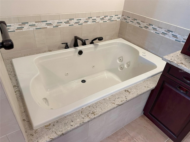 459 Haven Point Dr, Treasure Island, FL 33706 - bathroom with a jetted tub, vanity, and tile walls