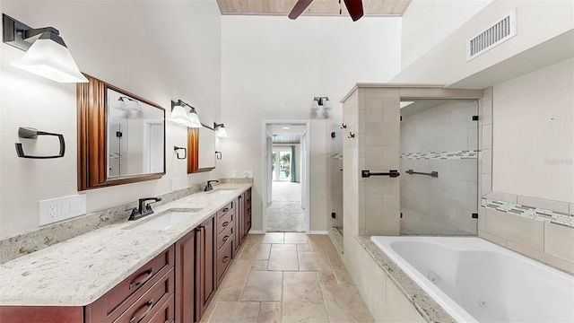 459 Haven Point Dr, Treasure Island, FL 33706 - bathroom with a tub with jets, double vanity, a tile shower, a ceiling fan, and a towering ceiling