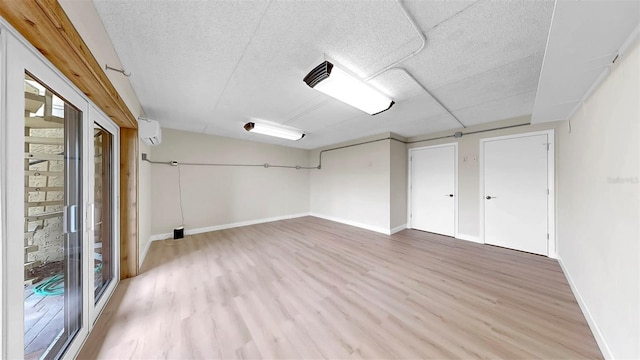 459 Haven Point Dr, Treasure Island, FL 33706 - below grade area featuring light wood-style flooring, a wall unit AC, and a textured ceiling