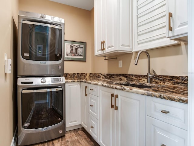 8 Sunset Bay Dr, Belleair, FL 33756 - laundry area featuring stacked washing machine and dryer, cabinet space, and wood finished floors