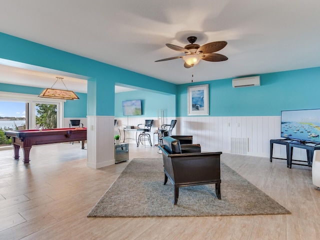 8 Sunset Bay Dr, Belleair, FL 33756 - living area featuring a wall mounted AC, wainscoting, wood finished floors, a ceiling fan, and pool table