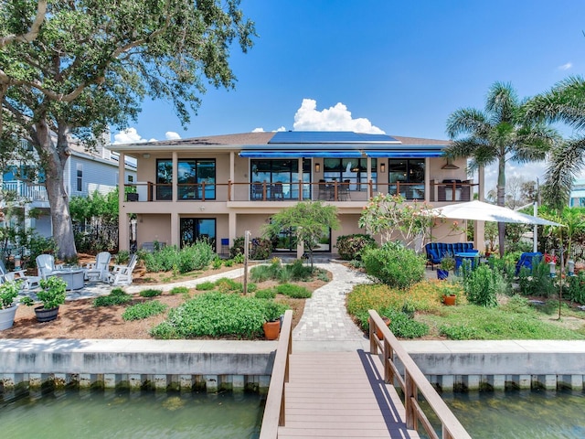 8 Sunset Bay Dr, Belleair, FL 33756 - back of house with stucco siding, a balcony, and a water view