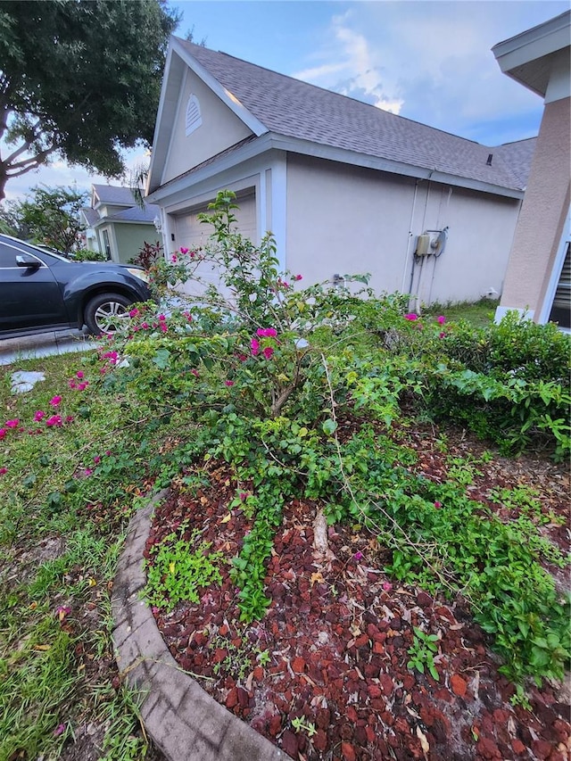10539 Egret Haven Ln, Riverview, FL 33578 - view of property exterior featuring stucco siding, an attached garage, and roof with shingles