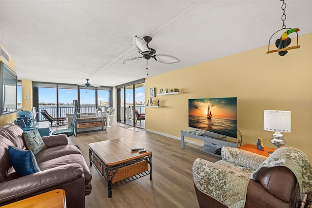 80 Rogers St Unit 3A, Clearwater, FL 33756 - living area featuring ceiling fan, wood finished floors, a textured ceiling, and a wall of windows