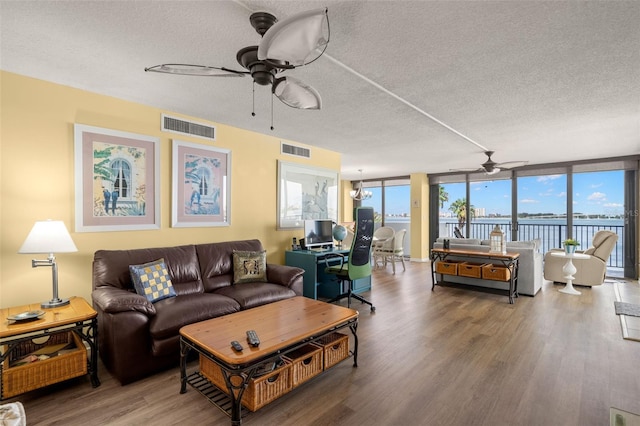 80 Rogers St Unit 3A, Clearwater, FL 33756 - living room featuring a ceiling fan, wood finished floors, a textured ceiling, and a wall of windows