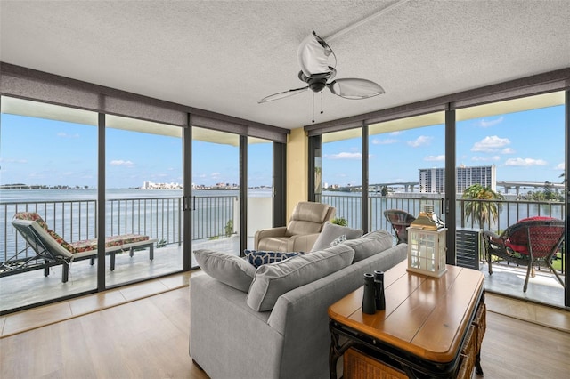 80 Rogers St Unit 3A, Clearwater, FL 33756 - sunroom / solarium with wood finished floors, a water view, a textured ceiling, expansive windows, and plenty of natural light