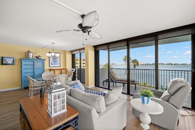 80 Rogers St Unit 3A, Clearwater, FL 33756 - living room with a textured ceiling, a chandelier, wood finished floors, ceiling fan, and a water view