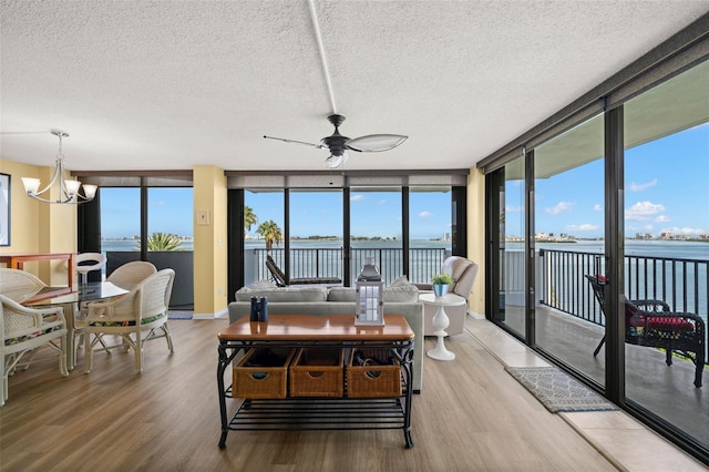 80 Rogers St Unit 3A, Clearwater, FL 33756 - living area featuring wood finished floors, ceiling fan, a water view, a chandelier, and a textured ceiling