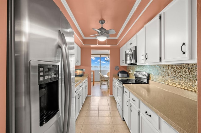80 Rogers St Unit 3A, Clearwater, FL 33756 - kitchen featuring appliances with stainless steel finishes, tasteful backsplash, a tray ceiling, white cabinets, and crown molding