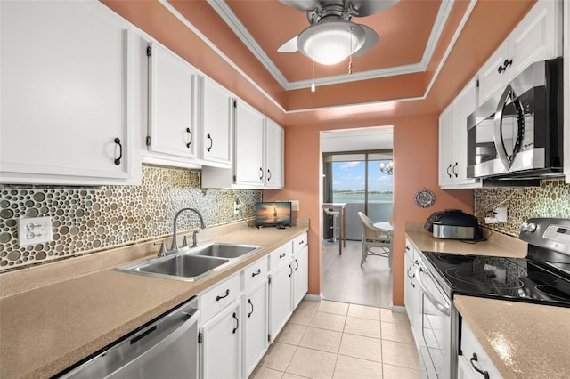 80 Rogers St Unit 3A, Clearwater, FL 33756 - kitchen featuring appliances with stainless steel finishes, a ceiling fan, white cabinets, tasteful backsplash, and ornamental molding