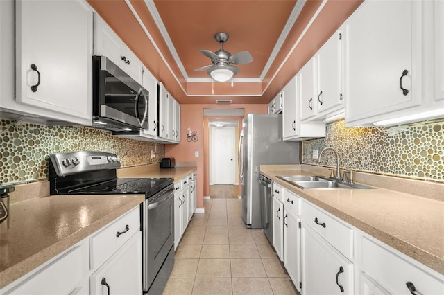 80 Rogers St Unit 3A, Clearwater, FL 33756 - kitchen with stainless steel appliances, a tray ceiling, a ceiling fan, white cabinets, and tasteful backsplash