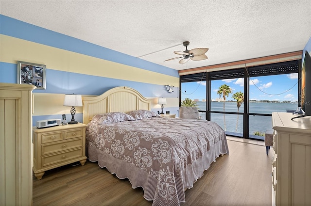 80 Rogers St Unit 3A, Clearwater, FL 33756 - bedroom featuring wood finished floors, expansive windows, access to exterior, a textured ceiling, and a ceiling fan