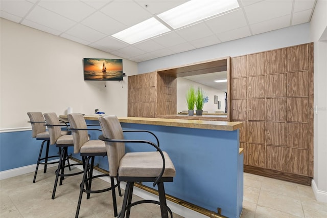 80 Rogers St Unit 3A, Clearwater, FL 33756 - kitchen with a breakfast bar, a drop ceiling, modern cabinets, light tile patterned floors, and a peninsula