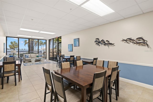 80 Rogers St Unit 3A, Clearwater, FL 33756 - dining space featuring a wall of windows, light tile patterned floors, and a drop ceiling