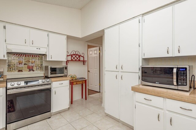 8629 Wolf Den Trl, Port Richey, FL 34668 - kitchen with stainless steel appliances, under cabinet range hood, decorative backsplash, light tile patterned floors, and light countertops