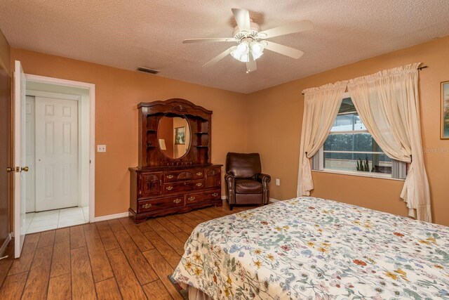 8629 Wolf Den Trl, Port Richey, FL 34668 - bedroom with hardwood / wood-style floors, a textured ceiling, and ceiling fan