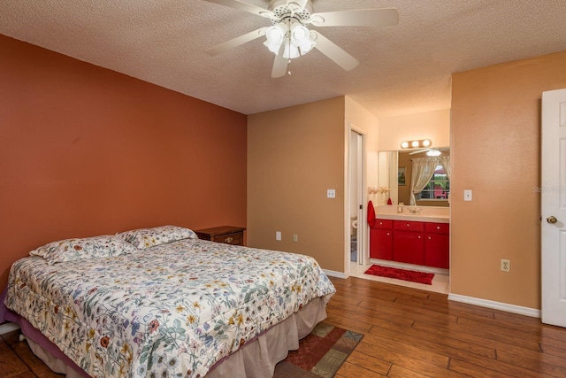 8629 Wolf Den Trl, Port Richey, FL 34668 - bedroom featuring hardwood / wood-style flooring, a textured ceiling, ceiling fan, and connected bathroom