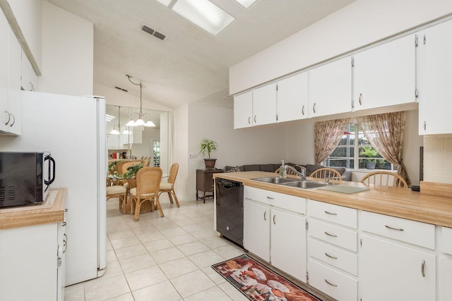 8629 Wolf Den Trl, Port Richey, FL 34668 - kitchen with black appliances, light tile patterned floors, lofted ceiling, white cabinets, and light countertops
