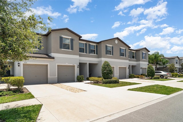 9741 Mulberry Marsh Ln, Sun City Center, FL 33573 - townhome / multi-family property with an attached garage, stucco siding, driveway, and a residential view