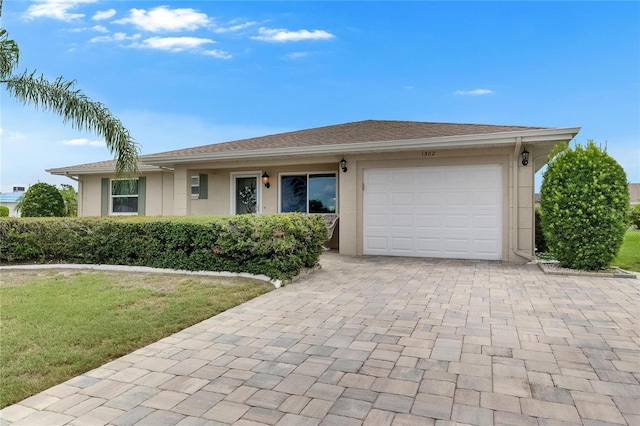 1502 Fort Duquesna Dr, Sun City Center, FL 33573 - view of front of house with a garage, decorative driveway, a front yard, and stucco siding