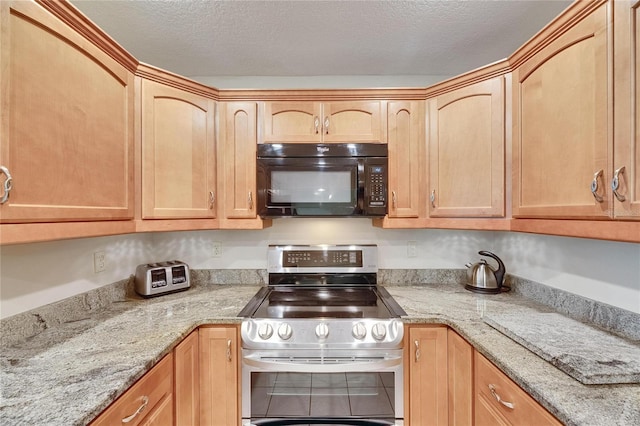 1502 Fort Duquesna Dr, Sun City Center, FL 33573 - kitchen featuring black microwave, range with two ovens, light stone countertops, a textured ceiling, and light brown cabinetry