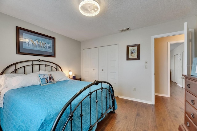 1502 Fort Duquesna Dr, Sun City Center, FL 33573 - bedroom with dark wood finished floors, a closet, and a textured ceiling