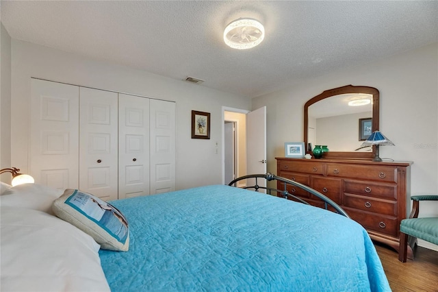 1502 Fort Duquesna Dr, Sun City Center, FL 33573 - bedroom featuring wood finished floors, a closet, and a textured ceiling